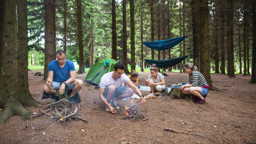 pracownicy rozpalający ogień w trakcie imprezy survivalowej